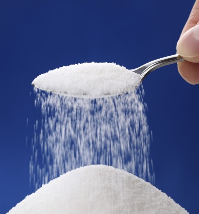 Heap of sugar and pouring more from a spoon